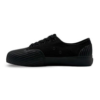 Side view of UNFORMED black canvas low-top sneakers